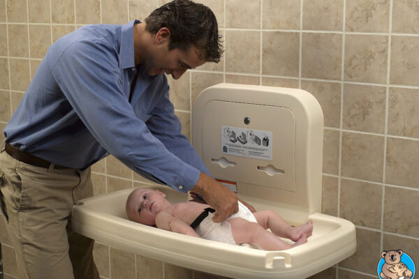 Man Pretending to Change Baby's Diaper on Beige Changing Table